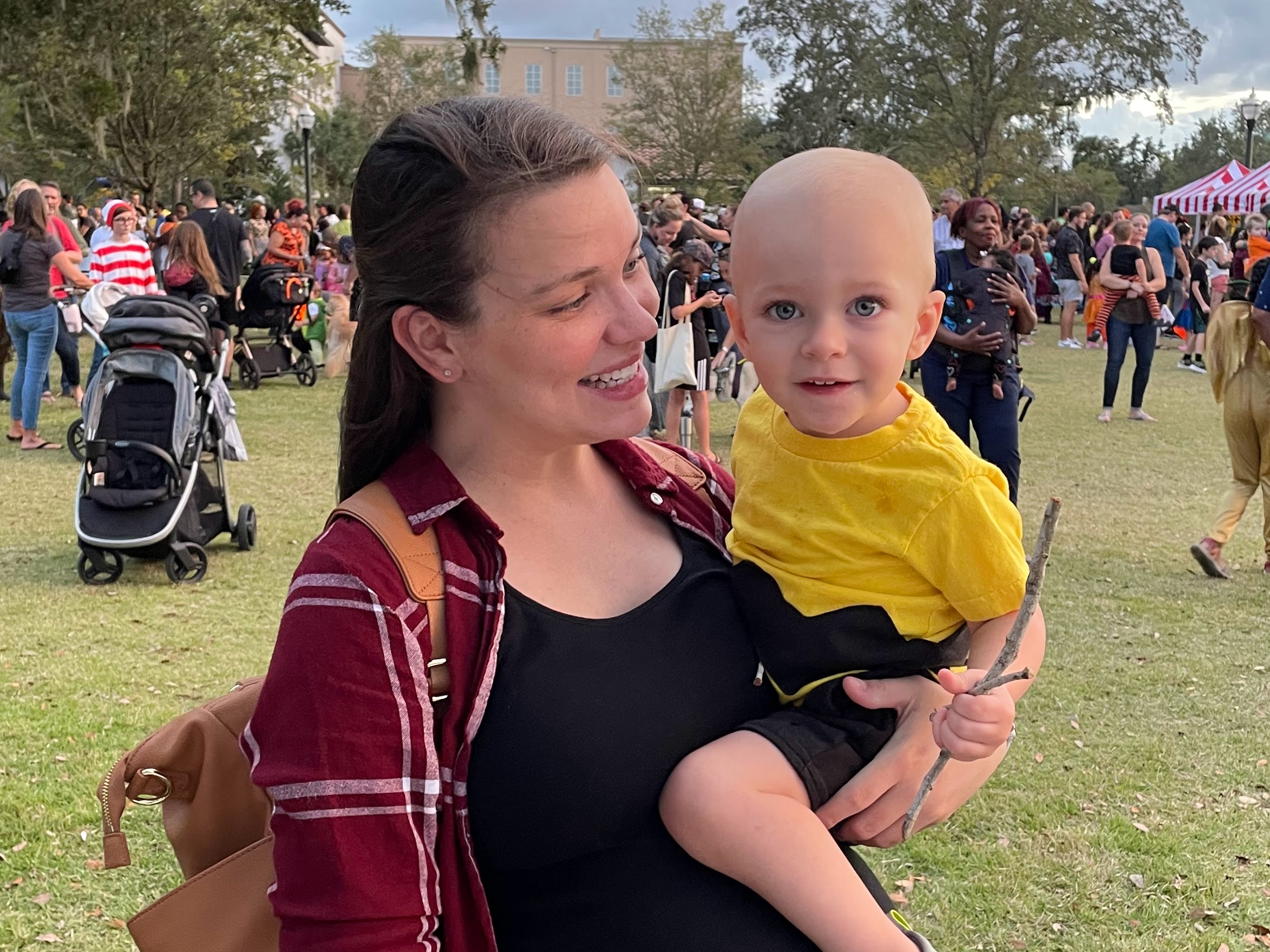 Cadie posing with her son at an outdoor family festival.