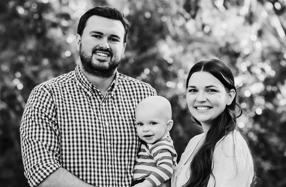 Cadie Stockman, her husband and child posing and smiling for a photo.